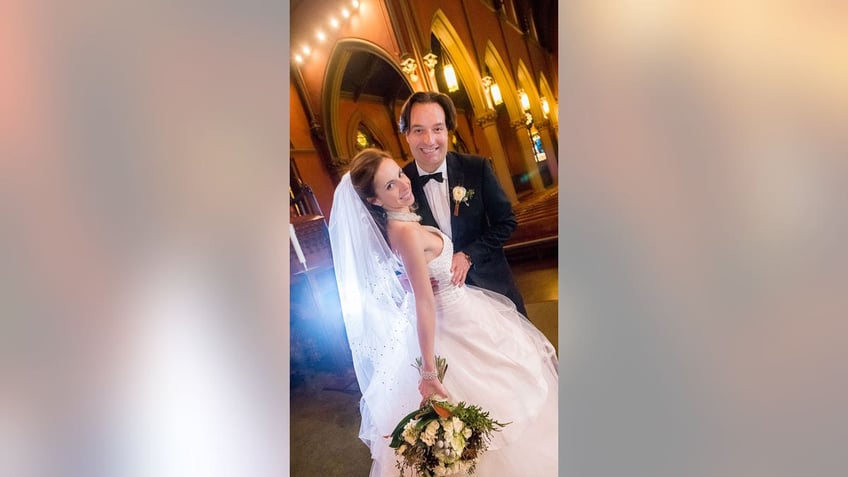 A bride and groom pose inside of a church