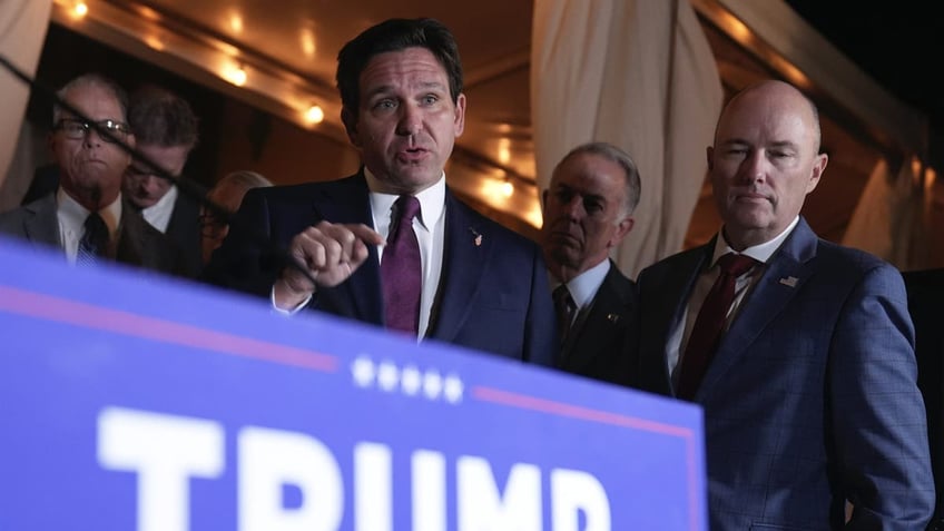 Florida Gov. Ron DeSantis speaks as Utah Gov. Spencer Cox, right, listens before President-elect Donald Trump talks at a meeting with Republican governors at Mar-a-Lago on Thursday, Jan. 9, 2025 in Palm Beach, Florida.