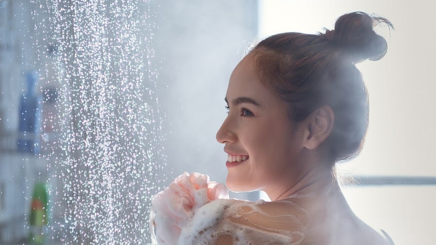 Woman showering with soap