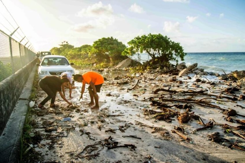 A photo taken on December 6, 2021 shows high-tide flooding and debris covering the road to