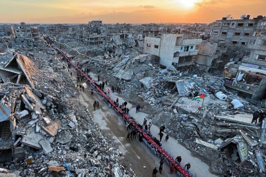 Hundreds sat on a long row of plastic chairs under bunting, Palestinian flags and lights s