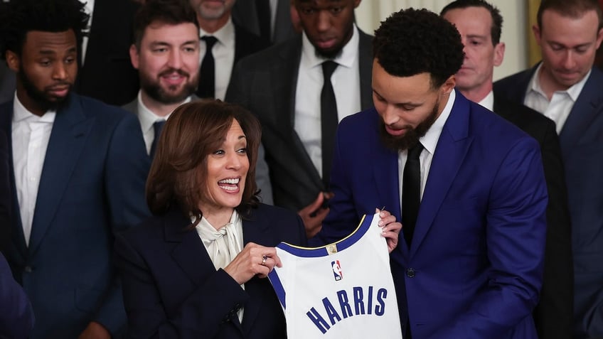 Golden State Warriors star Steph Curry presents U.S. Vice President Kamala Harris with a jersey.