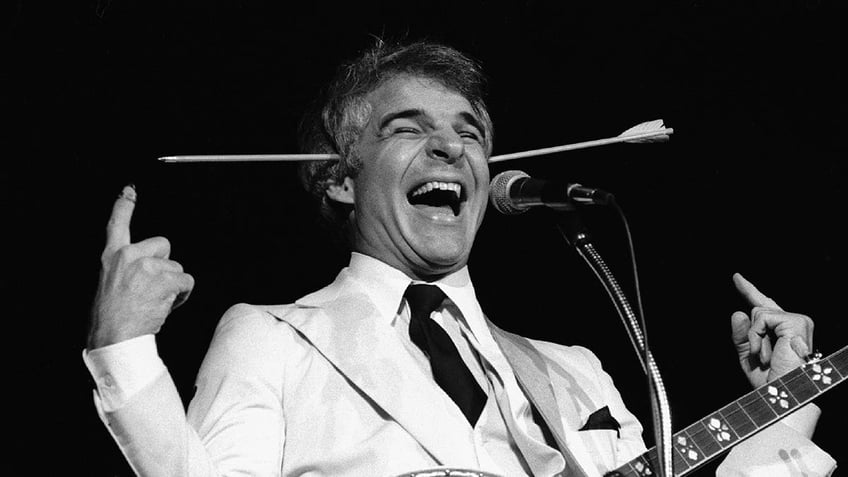 Black and white photo of Steve Martin with a prop arrow through his head