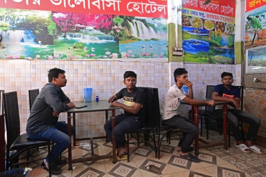 Naim Pramanik (2L), a garment worker who lost his job after joining wage protests last month, sits with union leader Prodip Ray (L) at a Dhaka restaurant