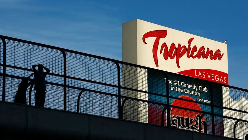 People standing on a pedestrian bridge by the Tropicana hotel and casino in Las Vegas