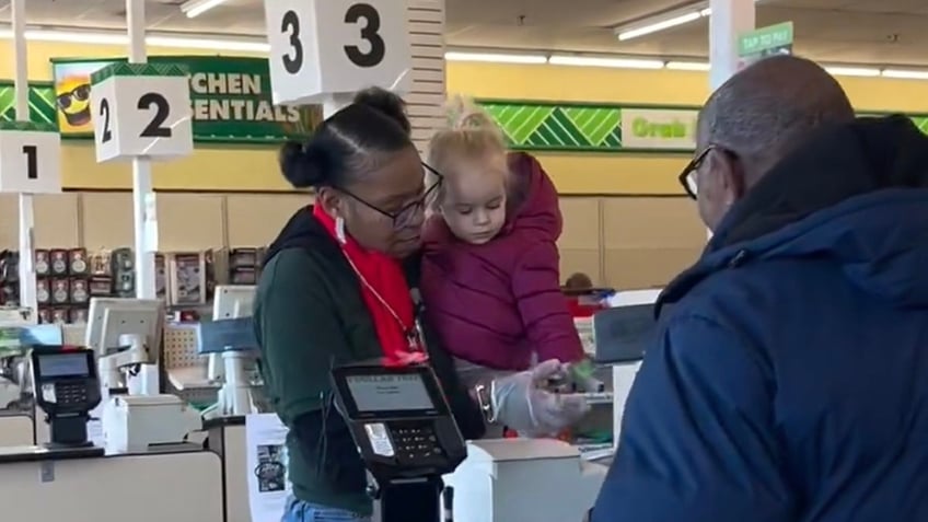 Supermarket cashier and toddler