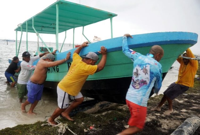 People secure their boats ahead of the arrival of Hurricane Helene in Cancun, Quintana Roo