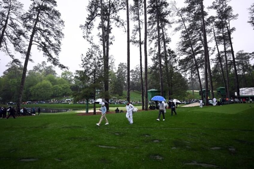 Players walk by the location where trees fell due to weather on the 17th hole last year du