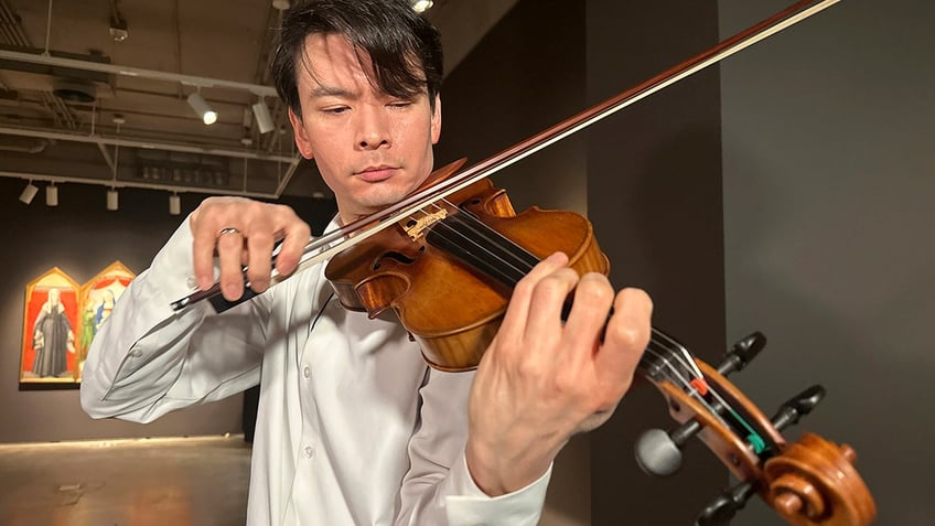 Violinist playing the auctioned violin