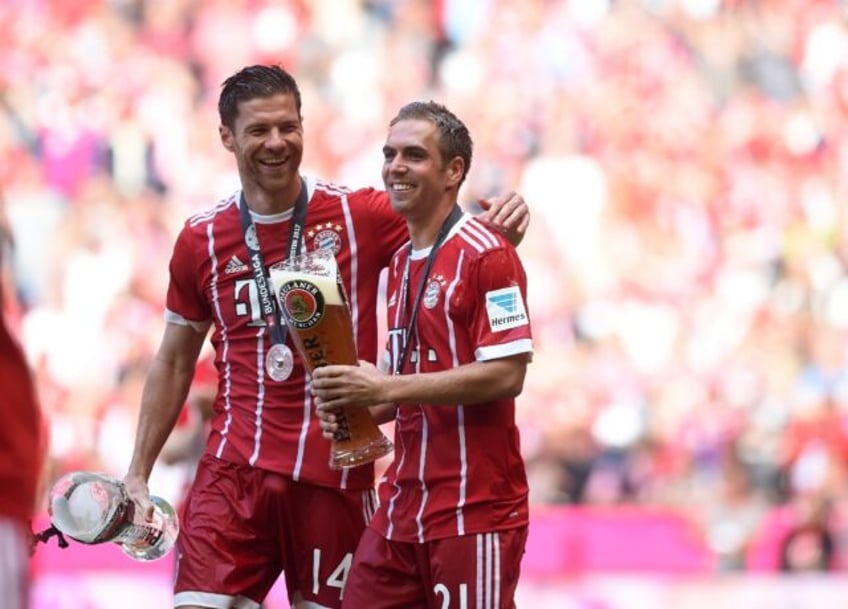 Bayern Munich teammates Philipp Lahm (R) and Xabi Alonso (L) celebrate together with a bee