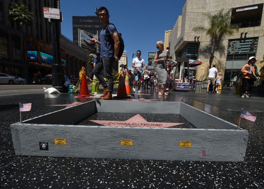 street artist erects mini border wall around donald trumps hollywood star