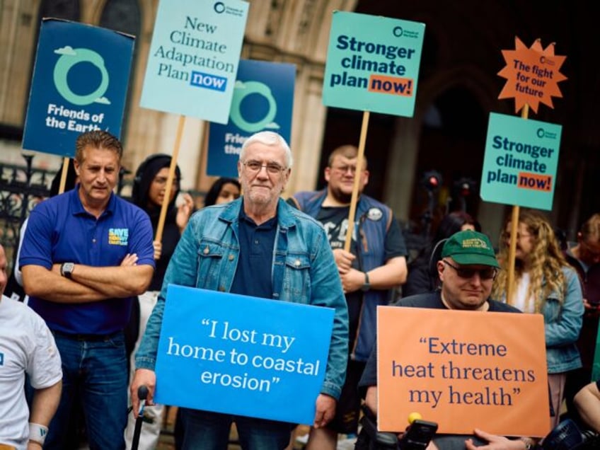 Kevin Jordan (C), holding a placard reading 'I lost my home to coastal erosion' demonstrat