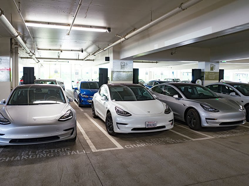 Four Tesla Model 3 electric cars from Tesla Motors are visible charging at an electric veh