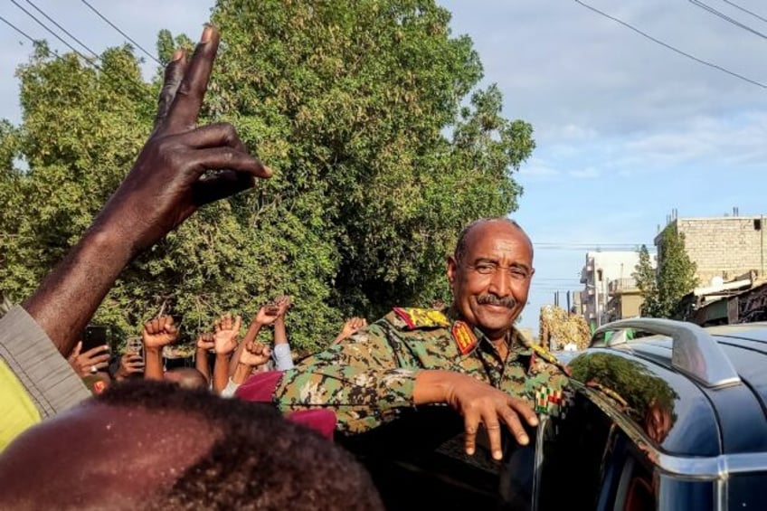 People cheer as Sudan's de facto leader, armed forces chief Abdel Fattah al-Burhan, arrive