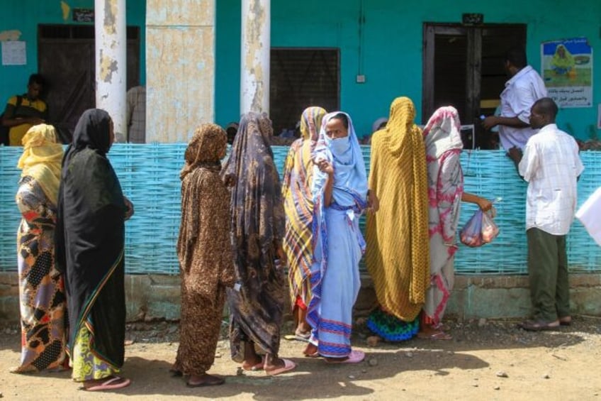 People queue to receive meat parcels in the eastern Sudanese city of Gedaref