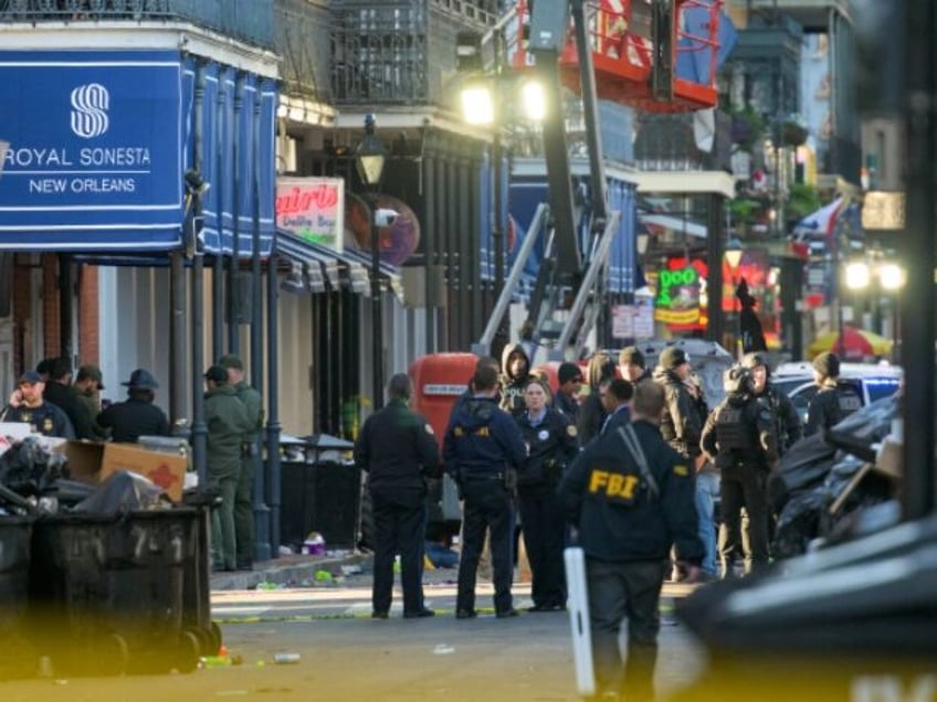 FBI investigators arrive at the scene where the white Ford F-150 pickup truck that crashed