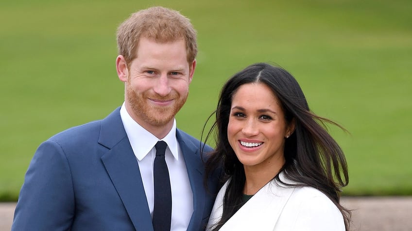 A close-up of Prince Harry and Meghan Markle smiling outdoors.