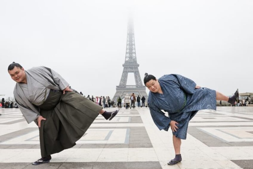 Tochitaikai (L) and Tochikodai pose in for a photo in front of the Eiffel Tower as they