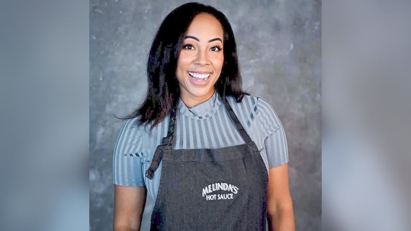 Erica Blaire Roby in an apron and striped shirt.