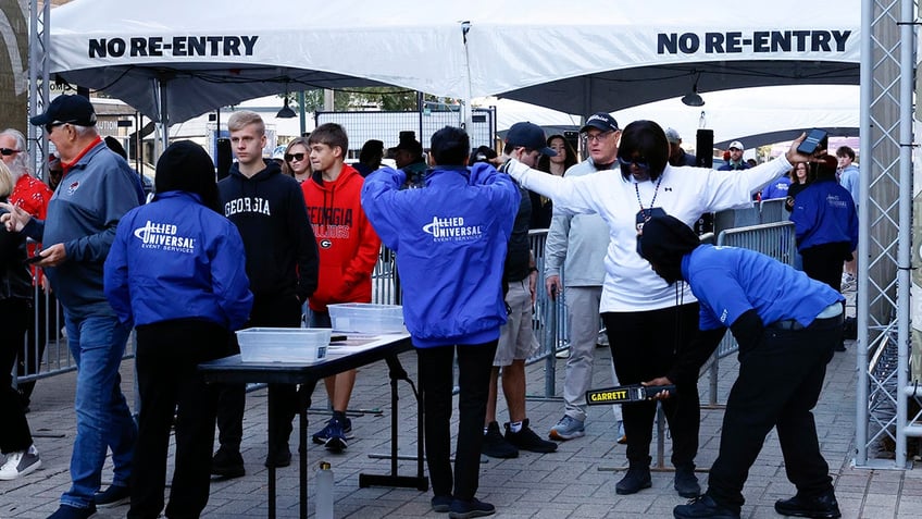 Fans pass through security check points as they enter the Caesars Superdome fan zone ahead of the Sugar Bowl NCAA College Football Playoff game, Thursday, Jan. 2, 2025, in New Orleans. 