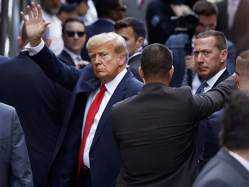 Former U.S. President Donald Trump waves as he arrives at the Manhattan Criminal Court for