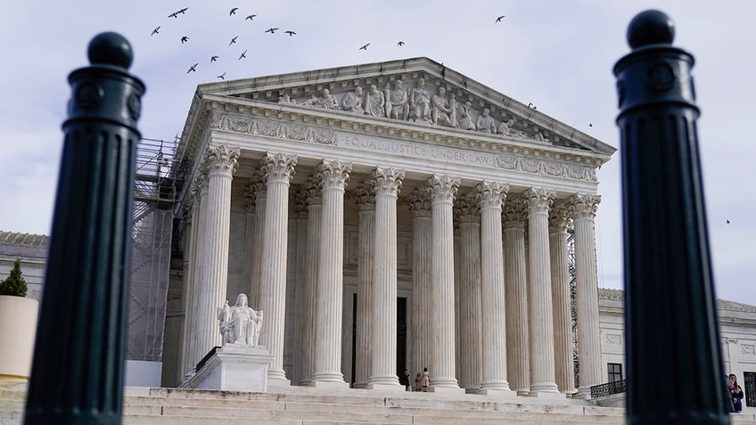 supreme court building seen looking upward from street, framed by bollards