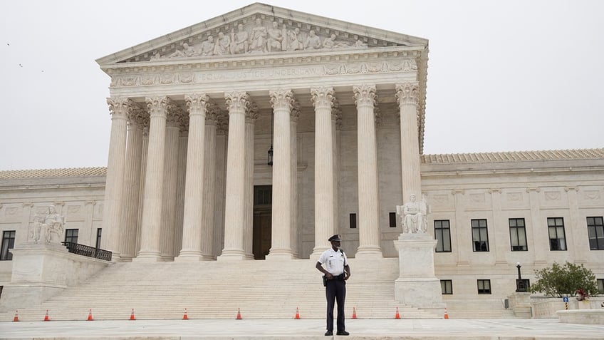 A police officer patrols in front of of the U.S. Supreme Court in Washington, D.C., on Tuesday, Oct. 12, 2021. (Emily Elconin/Bloomberg via Getty Images)