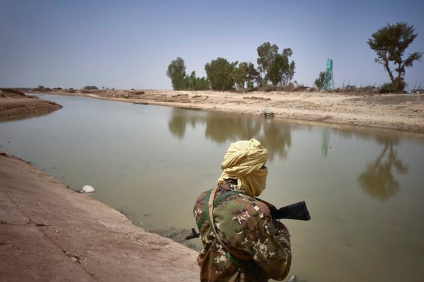 A soldier on patrol along a riverbank in Mali