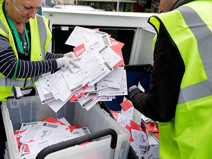 King County Election workers collect ballots from a drop box in the Washington State primary, Tuesday, March 10, 2020 in Seattle. Washington is a vote by mail state. (AP Photo/John Froschauer)