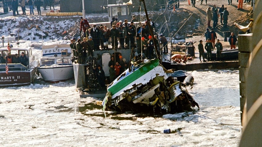 View, from a bridge, of a section of Air Florida Flight 90 as it is lifted via crane out of the Potomac River, Washington DC, January 20, 1982.