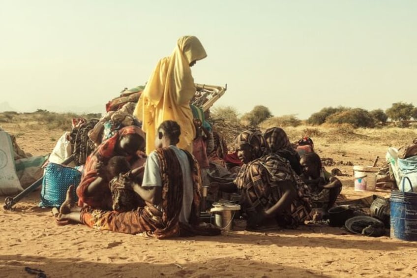 Sudanese women and children, who fled Zamzam camp, gather near the town of Tawila in North