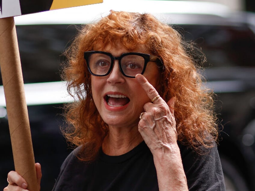 NEW YORK, NEW YORK - AUGUST 17: US Actress Susan Sarandon holds a banner as she joins WGA and SAG-AFTRA members hold a picket as they strike over contract negotiation at Netflix and Warner Bros. Discovery offices in New York on August 17, 2023. (Photo by Kena Betancur/VIEWpress via Getty …