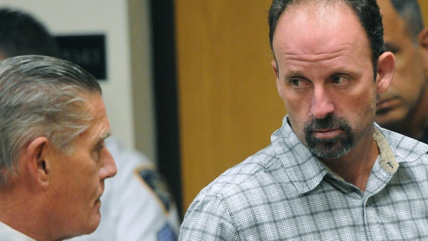 John Bittrolff listens to his attorney William Keahon during his arraignment on murder charges i