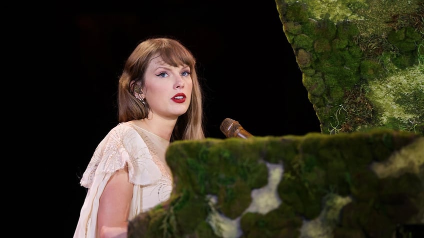 Taylor Swift sits at a piano during Eras Tour in Germany