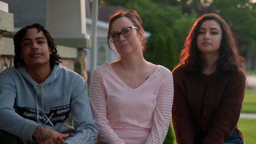 Noah, Amy and Kayla Hadley sit outside their house