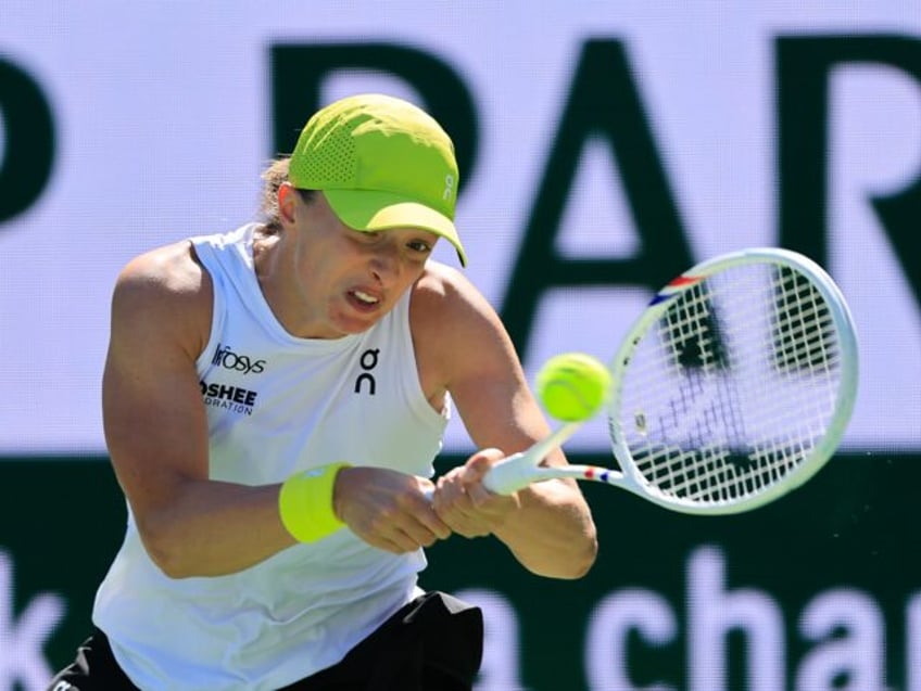 Defending champion Iga Swiatek of Poland plays a backhand on her way to a third-round vict