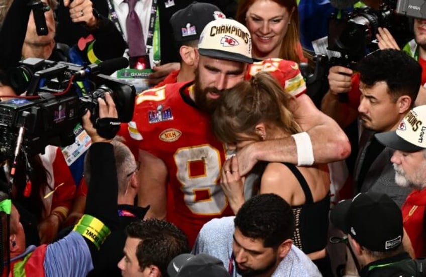 Taylor Swift and Kansas City Chiefs' tight end #87 Travis Kelce embrace after the Chiefs w