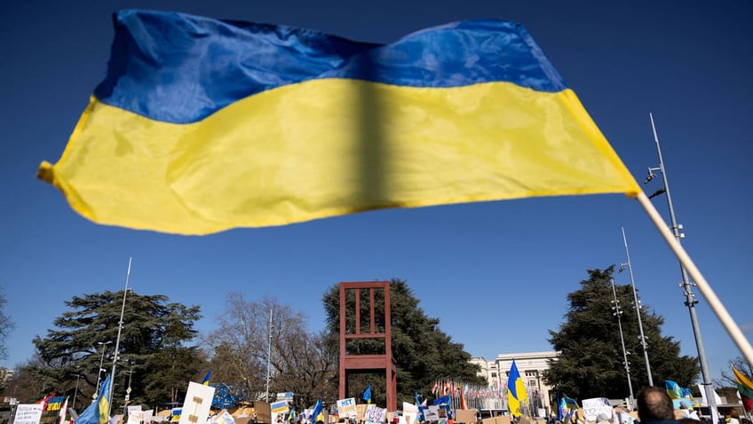 A Ukrainian flag is waved during an anti-war protest in front of the United Nations Office in Geneva, Switzerland