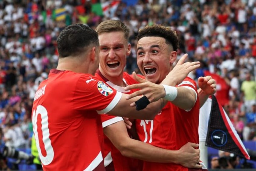 Switzerland's midfielder Ruben Vargas (R) celebrates with teammates after scoring his tea
