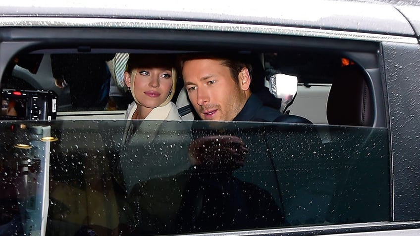 Sydney Sweeney looks at Glen Powell in a car as the window goes up 