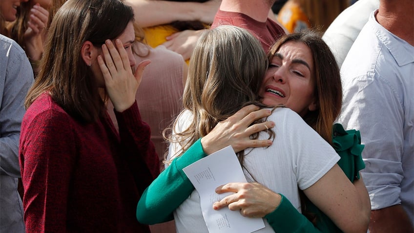 people hug at langford funeral