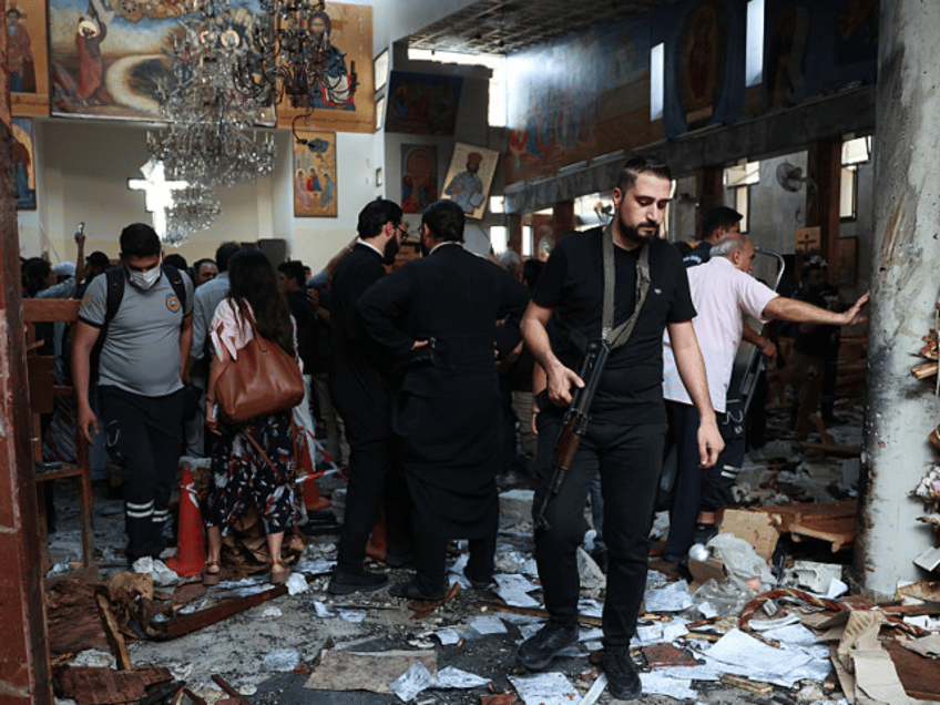 DAMASCUS, SYRIA - JUNE 22: An armed man inspects damage at the Mar Elias Church following
