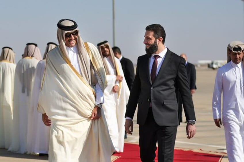 Qatar's Emir Sheikh Tamim bin Hamad Al-Thani (L) is welcomed by Syria's interim president