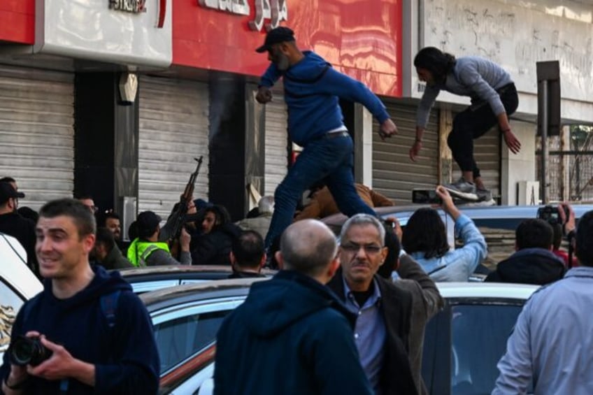 A gunman fires shots in the air to disperse clashing protesters in Syria's capital Damascu