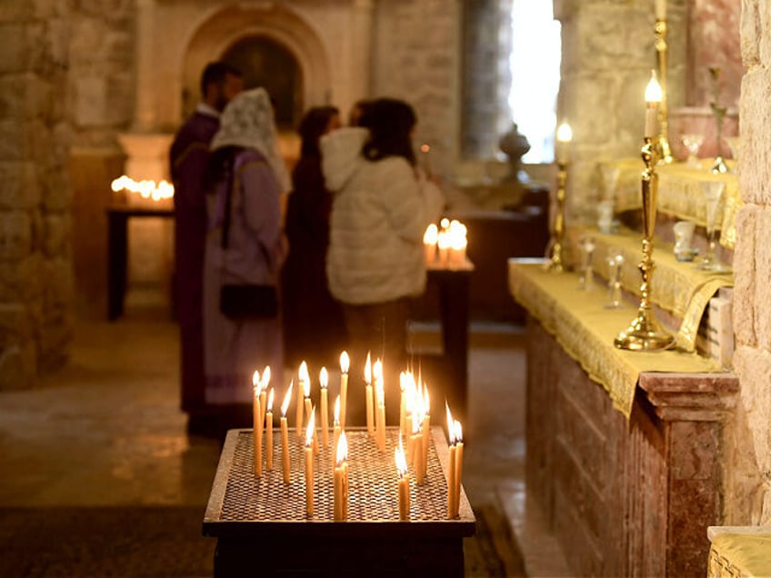 Worshippers light candles at the Armenian Orthodox Church in the Old City of Aleppo in nor