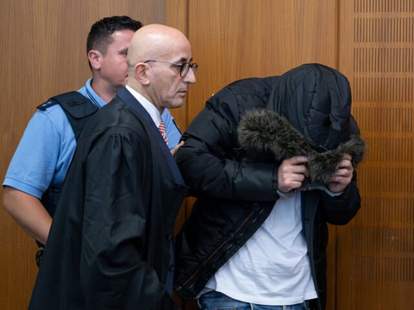 16 June 2025, Hesse, Frankfurt/Main: The accused Syrian doctor (r) is led into the courtro