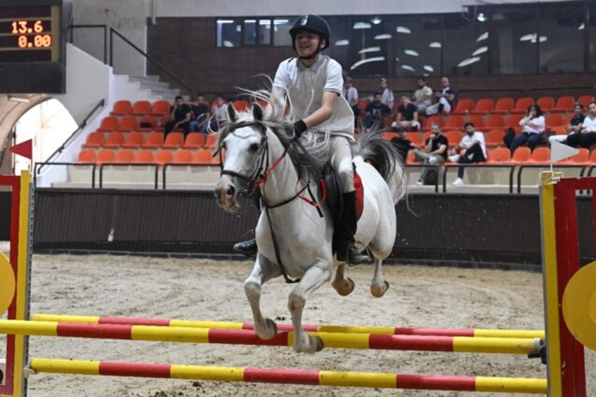 A rider competes at the Al-Nasr Equestrian Show Jumping Championship in Dimas, northwest o