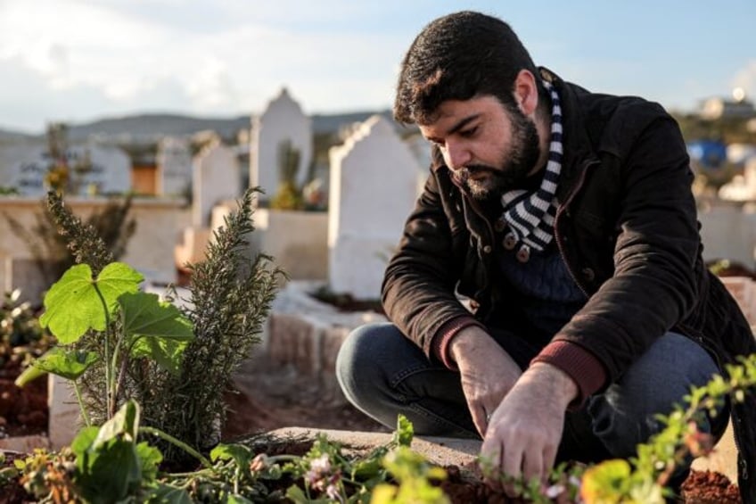 Ahmed al-Hakim by the tomb of his brother, whose death triggered rare protests in Syria's