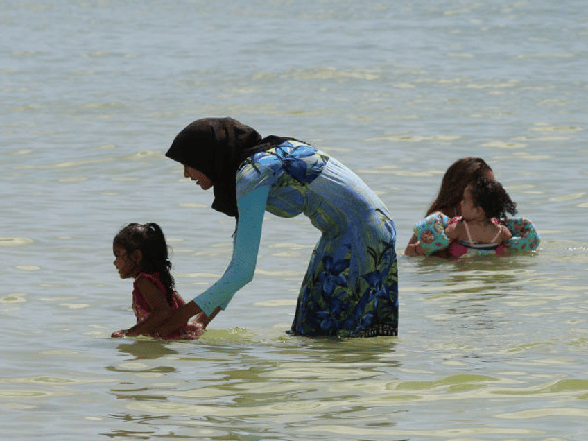 Muslim woman wearing a burkini while enjoying the warm water in the Gulf of Mexico at San
