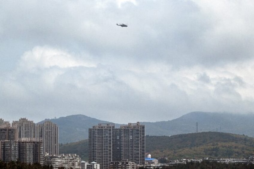 A Chinese military helicopter flies over Pingtan island, the closest point in China to Tai